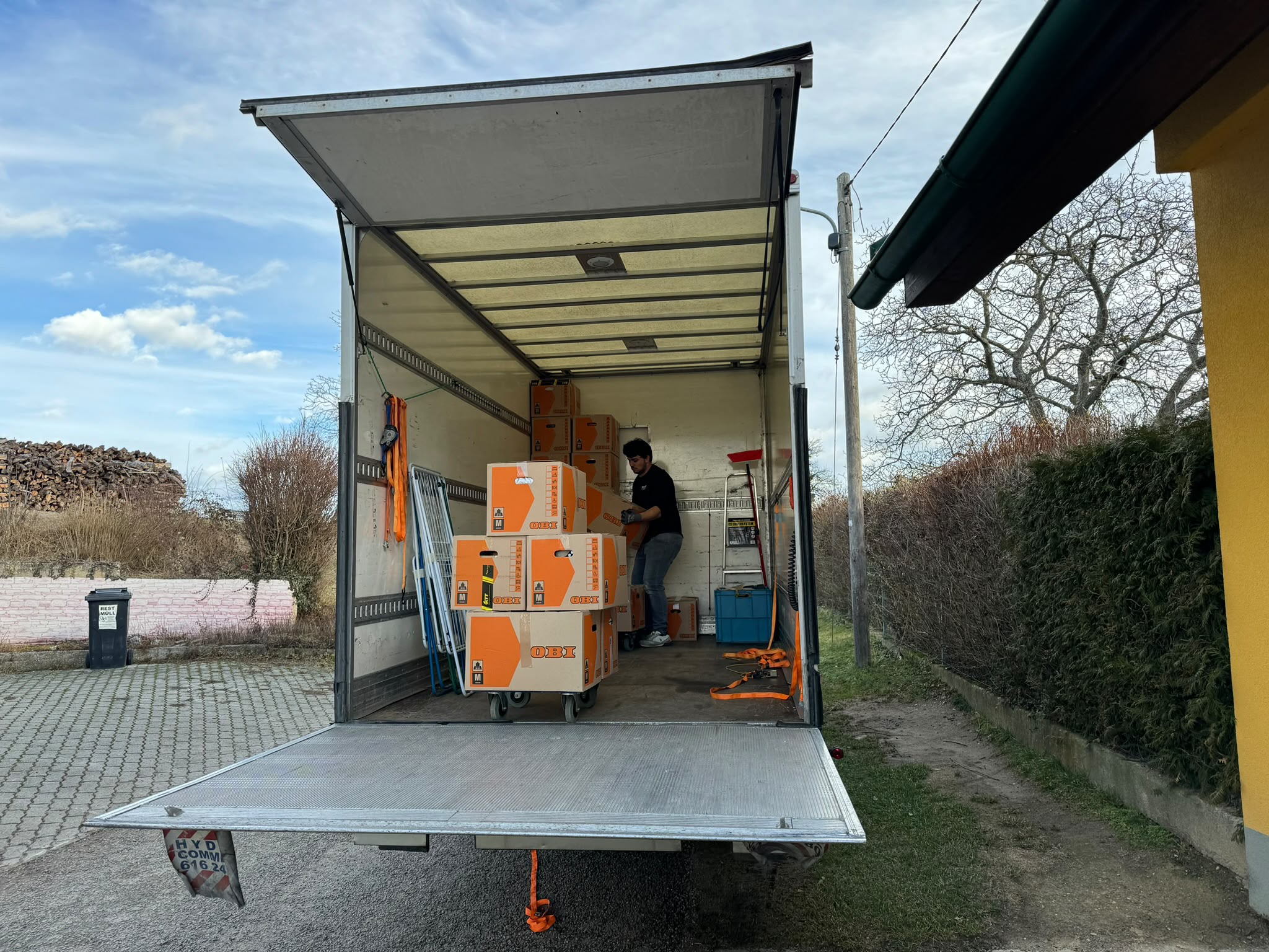 Mitarbeiter verlädt Umzugskartons auf Rollbrettern